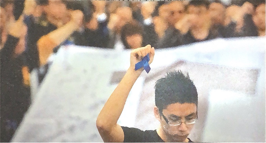 2014年「反暴力，緝真兇，護法治」，以藍色絲帶為標誌。最終警方緝拿襲擊劉進圖的兩刀手，是數十年來襲擊新聞工作者的行兇者中，首批受到法律制裁的人。（撮自香港記者協會《逆風．堅持：香港記者協會五十周年》）