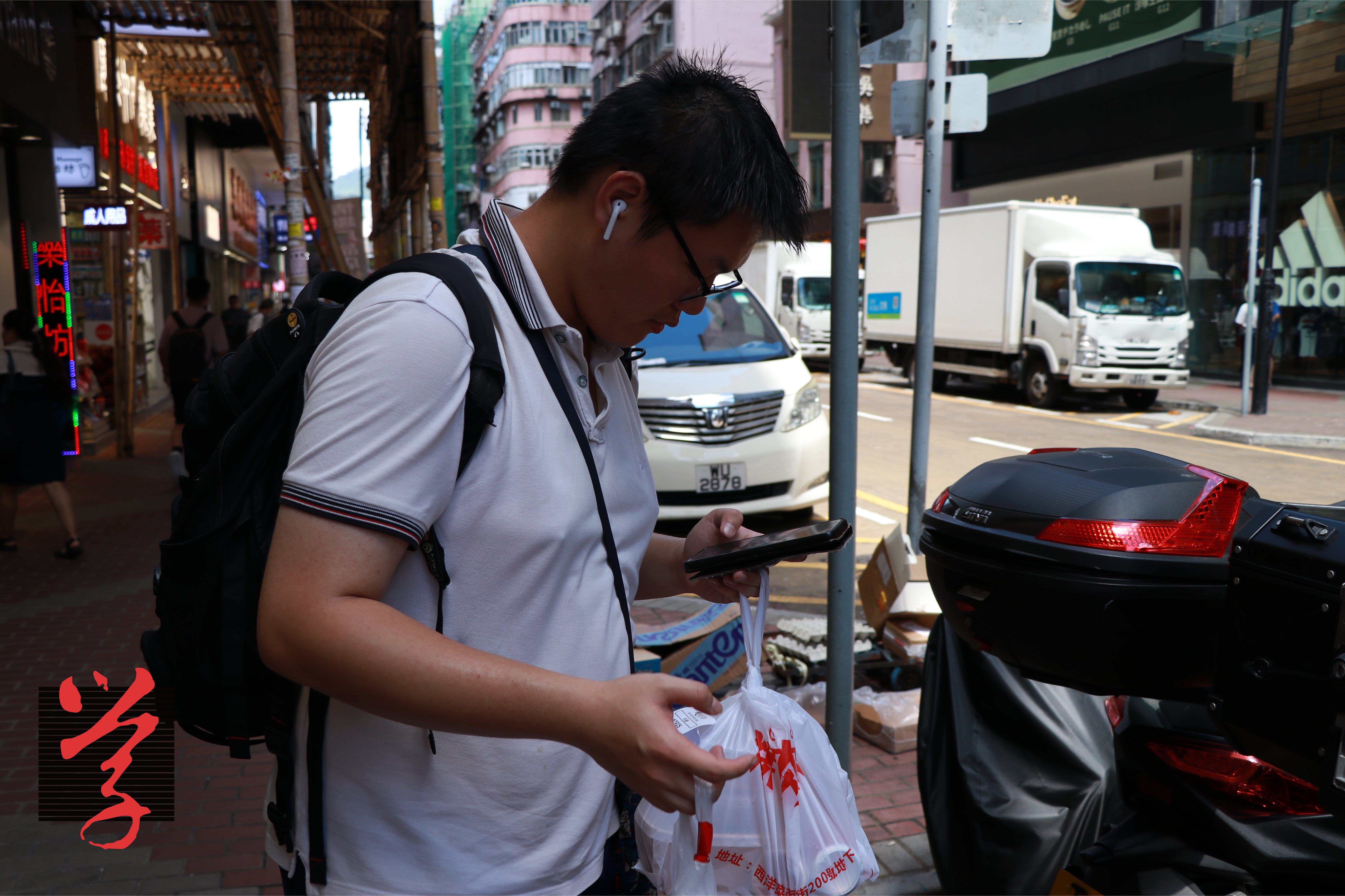 外賣員Cartman在午市高峰時段送外賣，期間一直汗流滿面，並需不時在手機確認位置。（鍾浩程攝）「大學線」被平台操控 急步啞忍的外賣員